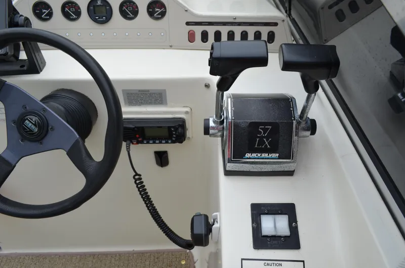 Slide: The Image of 1996 Rinker 300 Fiesta Vee boat dashboard with steering wheel and throttle controls. - 26