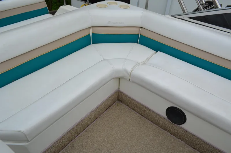 Slide: The Image of Interior seating of a 1996 Rinker 300 Fiesta Vee boat, featuring white and teal upholstery. - 28
