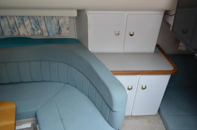 Slide: The Image of Interior of 1996 Rinker 300 Fiesta Vee with blue seating and white cabinets. - 33