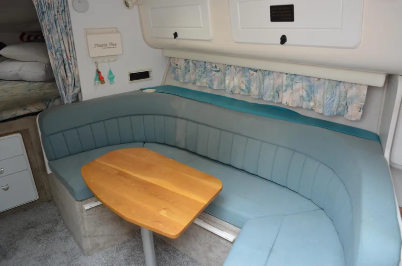 Slide: The Image of Interior of 1996 Rinker 300 Fiesta Vee boat with blue seating and wooden table. - 34