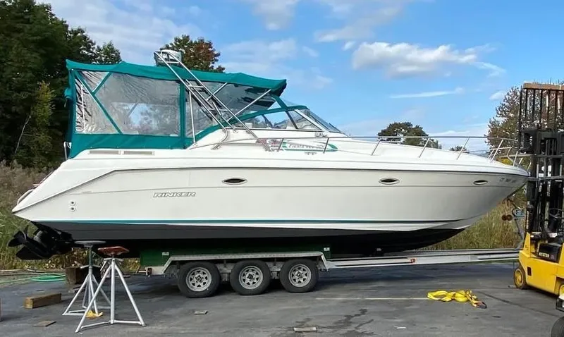 Slide: The Image of 1996 Rinker 300 Fiesta Vee boat on trailer with green canopy, outdoors. - 4