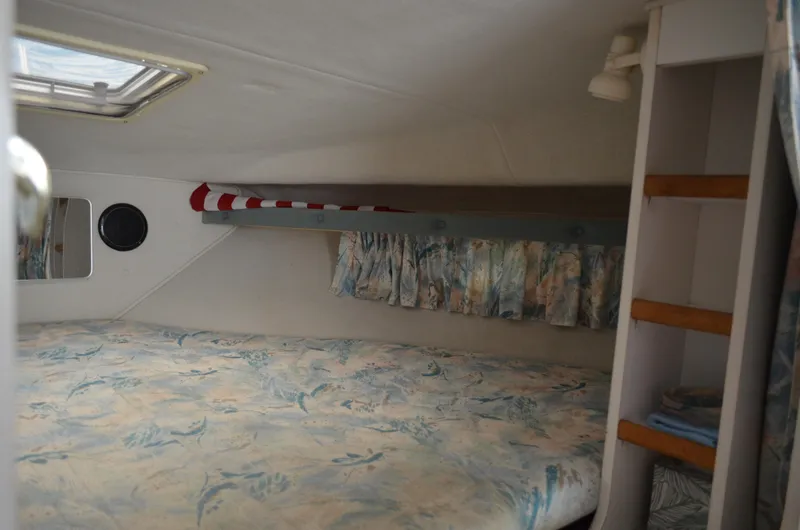 Slide: The Image of 1996 Rinker 300 Fiesta Vee cabin interior with bed, shelves, and window. - 40