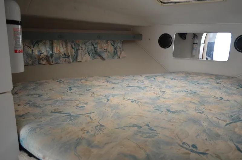 Slide: The Image of 1996 Rinker 300 Fiesta Vee cabin interior with patterned bedding and curtains. - 41