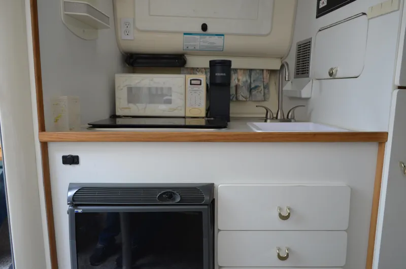 Slide: The Image of 1996 Rinker 300 Fiesta Vee boat kitchen with microwave, coffee maker, and sink. - 42