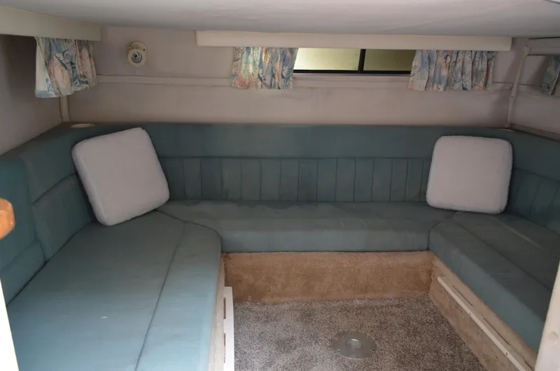 Slide: The Image of Interior of 1996 Rinker 300 Fiesta Vee boat with blue seating and patterned curtains. - 45