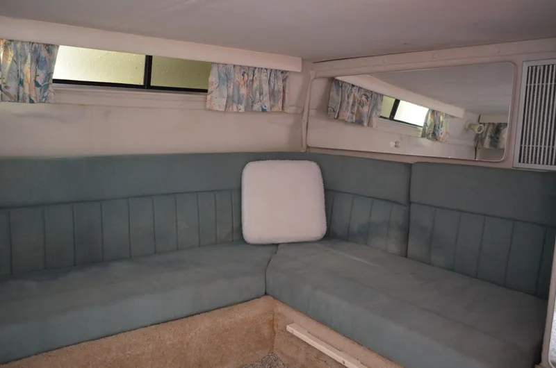 Slide: The Image of Interior of 1996 Rinker 300 Fiesta Vee boat with blue seating and patterned curtains. - 46