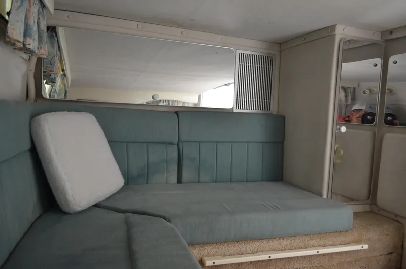 Slide: The Image of Interior of 1996 Rinker 300 Fiesta Vee boat with teal seating and mirrored cabinets. - 47