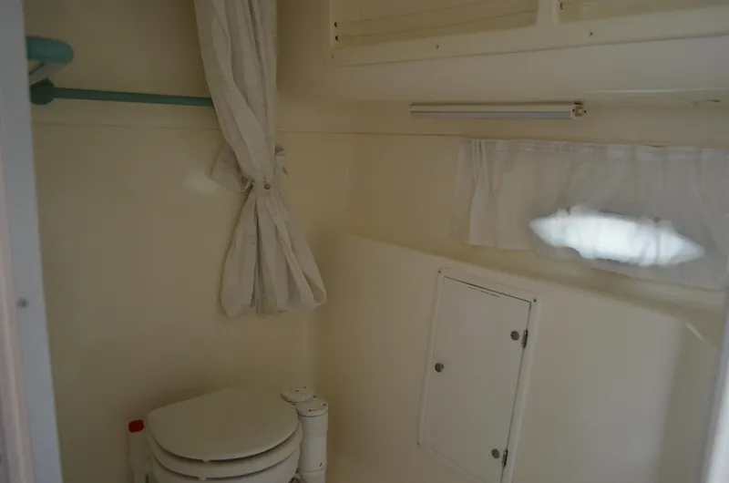 Slide: The Image of 1996 Rinker 300 Fiesta Vee boat bathroom with toilet and curtain. - 49