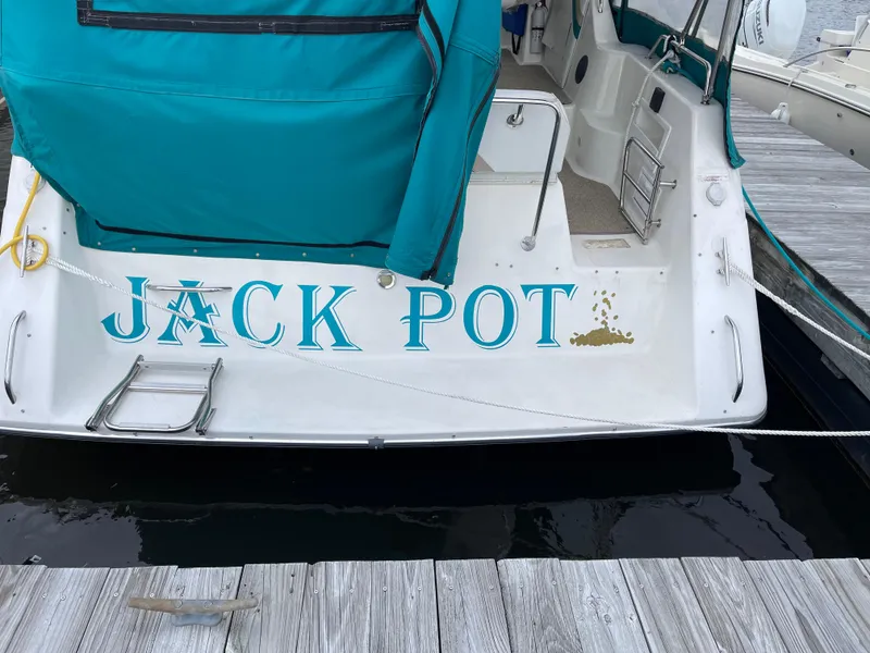 Slide: The Image of 1996 Rinker 300 Fiesta Vee boat named "Jack Pot" docked at a marina. - 6