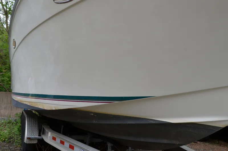 Slide: The Image of 1996 Rinker 300 Fiesta Vee boat on trailer, side view, white hull with green stripe. - 9