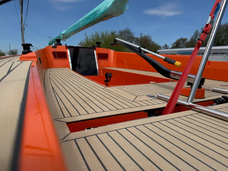 Slide: The Image of 2025 Saffier 24 Lite sailboat with orange deck and modern fittings under blue sky. - 2