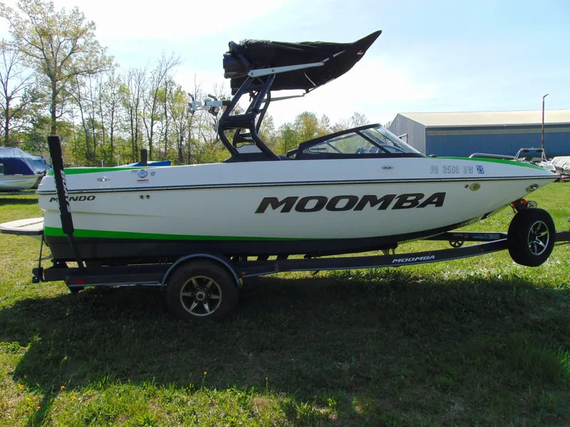 Slide: The Image of 2018 Moomba Mondo boat on trailer, green and white, parked on grass. - 10