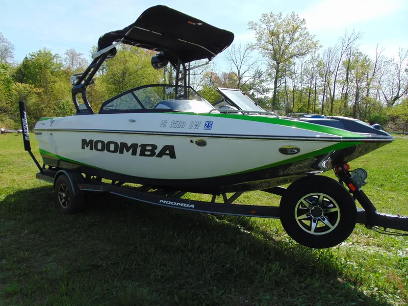 Slide: The Image of 2018 Moomba Mondo boat on trailer in grassy area, surrounded by trees. - 11