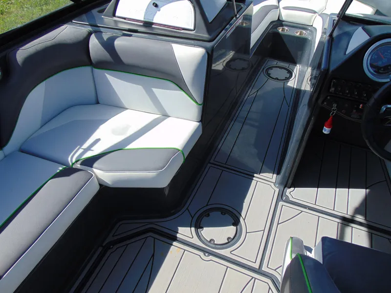 Slide: The Image of 2018 Moomba Mondo boat interior with gray and white seating, green accents, and sleek dashboard. - 19