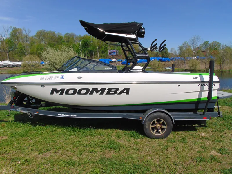 Slide: The Image of 2018 Moomba Mondo boat on trailer, white with green accents, parked on grass. - 5
