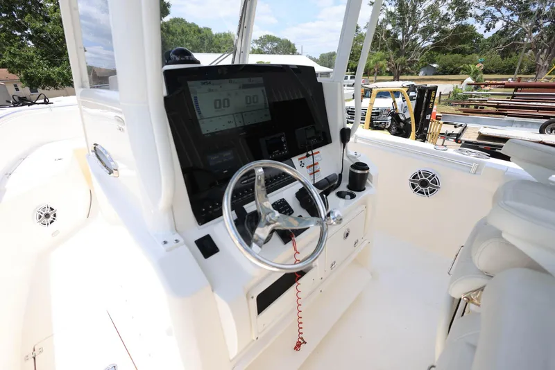 Slide: The Image of 2022 Cobia 301 Center Console boat dashboard with steering wheel and controls. - 11
