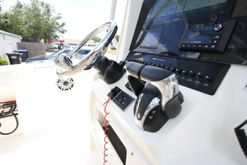 Slide: The Image of 2022 Cobia 301 Center Console boat dashboard with steering wheel and controls. - 13