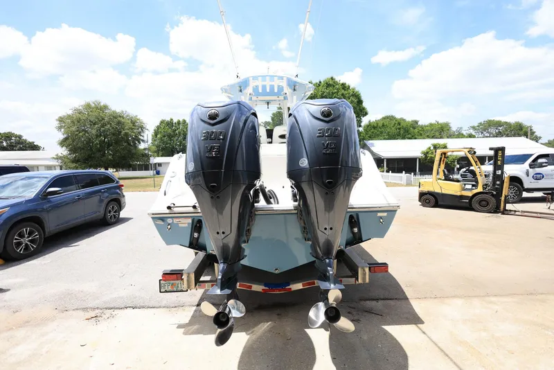 Slide: The Image of 2022 Cobia 301 Center Console with dual outboard engines, parked outdoors. - 2