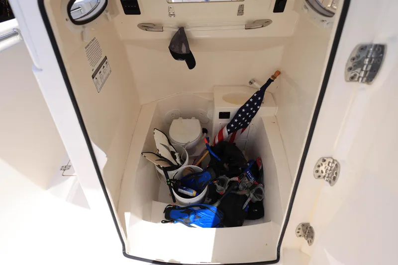 Slide: The Image of 2022 Cobia 301 Center Console storage area with gear and American flag. - 20