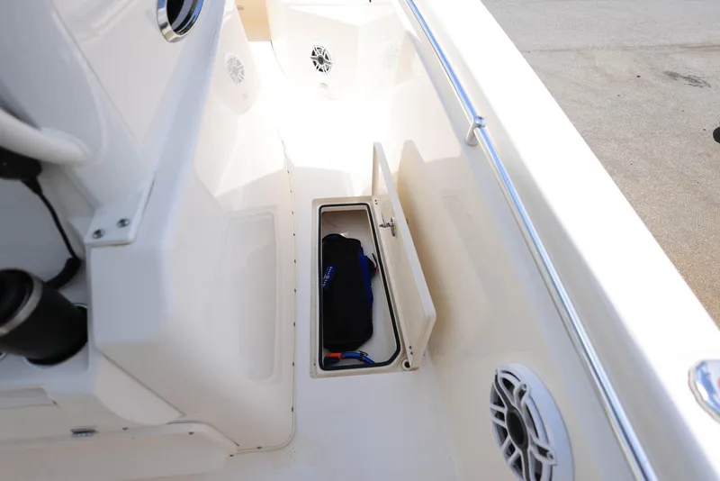 Slide: The Image of 2022 Cobia 301 Center Console boat with open storage compartment and speakers. - 22