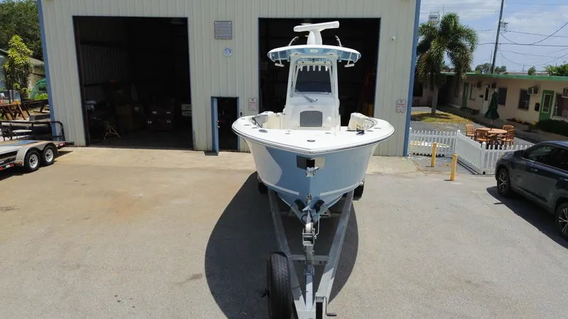 Slide: The Image of 2022 Cobia 301 Center Console boat on trailer outside a garage. - 26