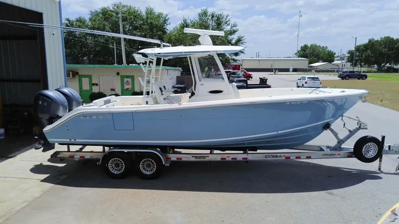 Slide: The Image of 2022 Cobia 301 Center Console boat on trailer, parked outdoors. - 27
