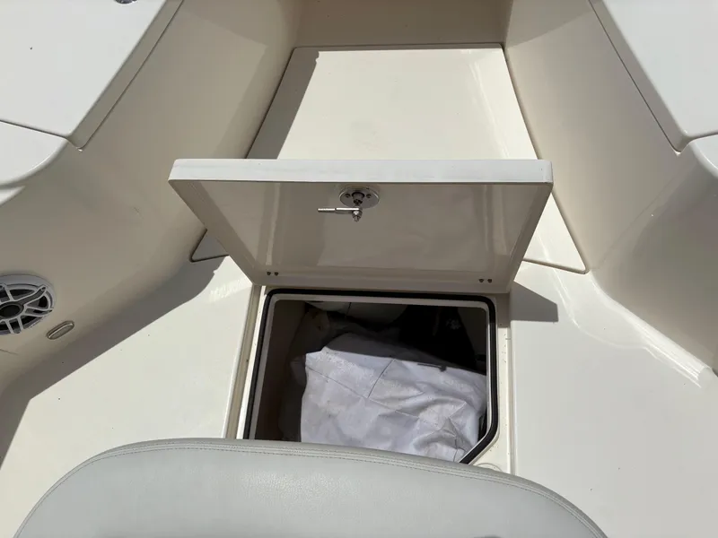 Slide: The Image of 2022 Cobia 301 Center Console storage compartment with open hatch, revealing interior space. - 30