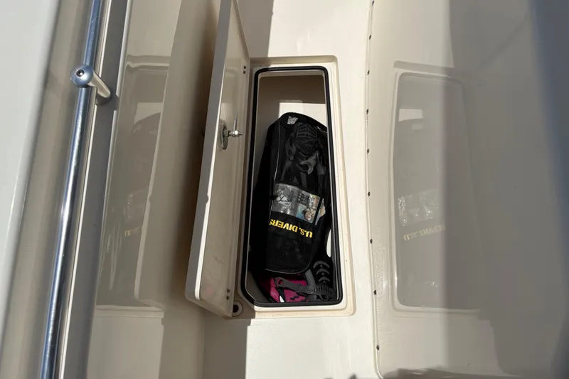 Slide: The Image of Storage compartment on 2022 Cobia 301 Center Console boat with gear inside. - 34