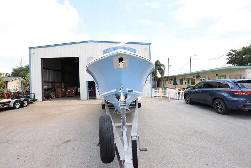 Slide: The Image of 2022 Cobia 301 Center Console boat on trailer outside a warehouse. - 5