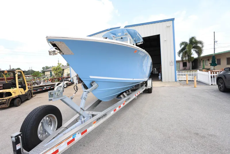 Slide: The Image of 2022 Cobia 301 Center Console boat on trailer outside a warehouse. - 6
