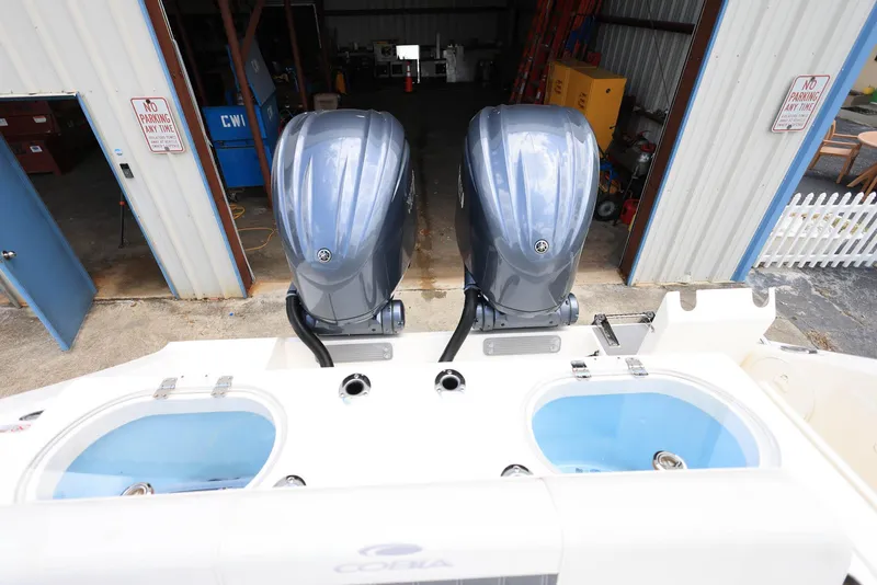 Slide: The Image of 2022 Cobia 301 Center Console with dual outboard engines in a storage facility. - 7