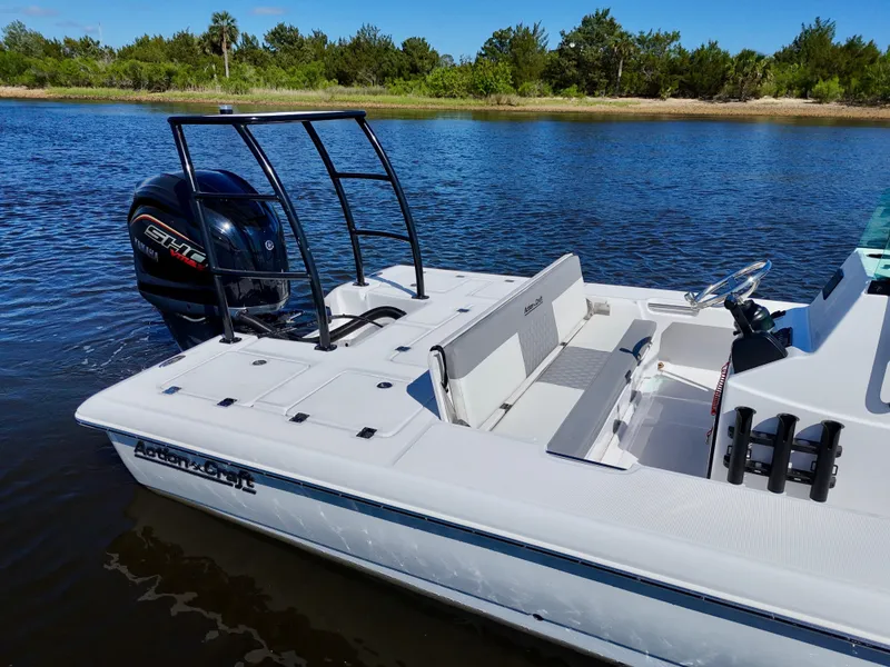 Slide: The Image of 2025 Action Craft 20 Flats boat on calm water, featuring sleek design and powerful engine. - 20