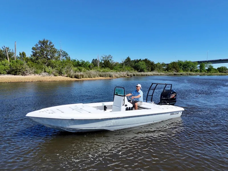 Slide: The Image of 2025 Action Craft 20 Flats boat cruising on a calm river under clear blue skies. - 8