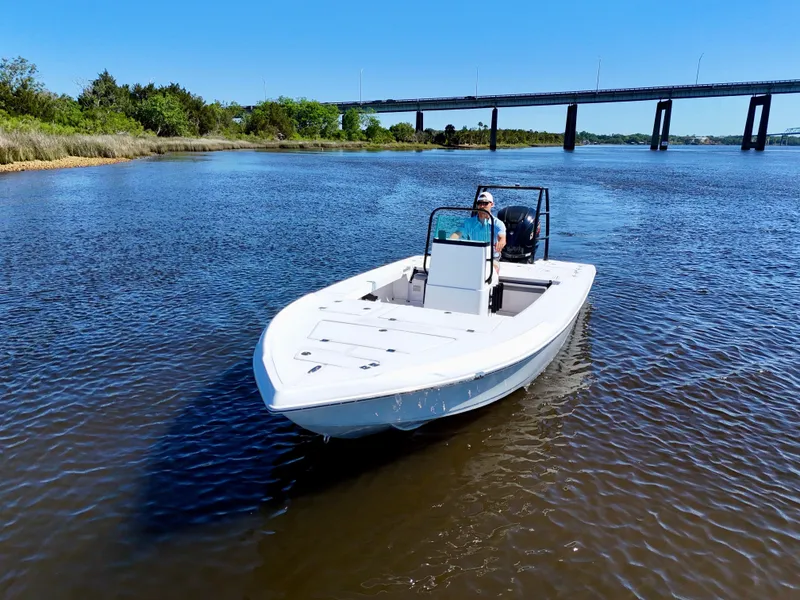 Slide: The Image of 2025 Action Craft 20 Flats boat cruising on a calm river near a bridge. - 9