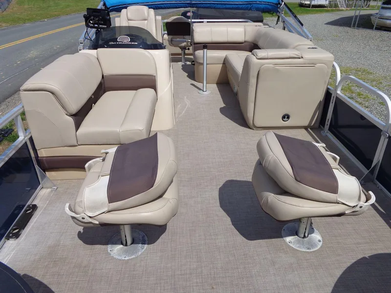 Slide: The Image of 2019 Sun Tracker Fishin' Barge 22 DLX interior with beige seating and fishing chairs. - 10