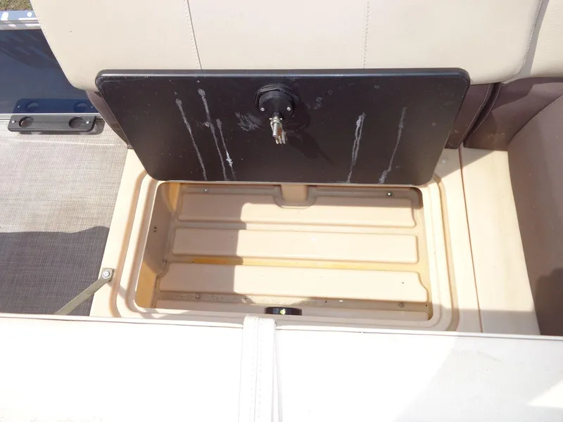 Slide: The Image of 2019 Sun Tracker Fishin' Barge 22 DLX storage compartment with open lid and key lock. - 19