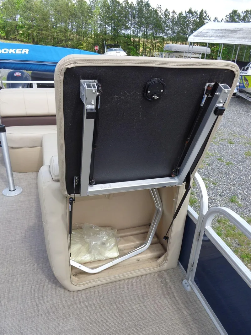 Slide: The Image of 2019 Sun Tracker Fishin' Barge 22 DLX seat storage compartment open, revealing interior space. - 25