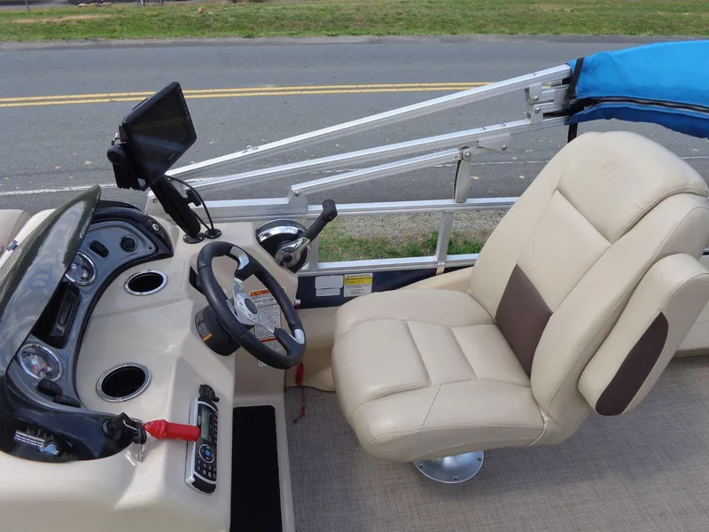 Slide: The Image of 2019 Sun Tracker Fishin' Barge 22 DLX helm with beige captain's chair and control panel. - 27