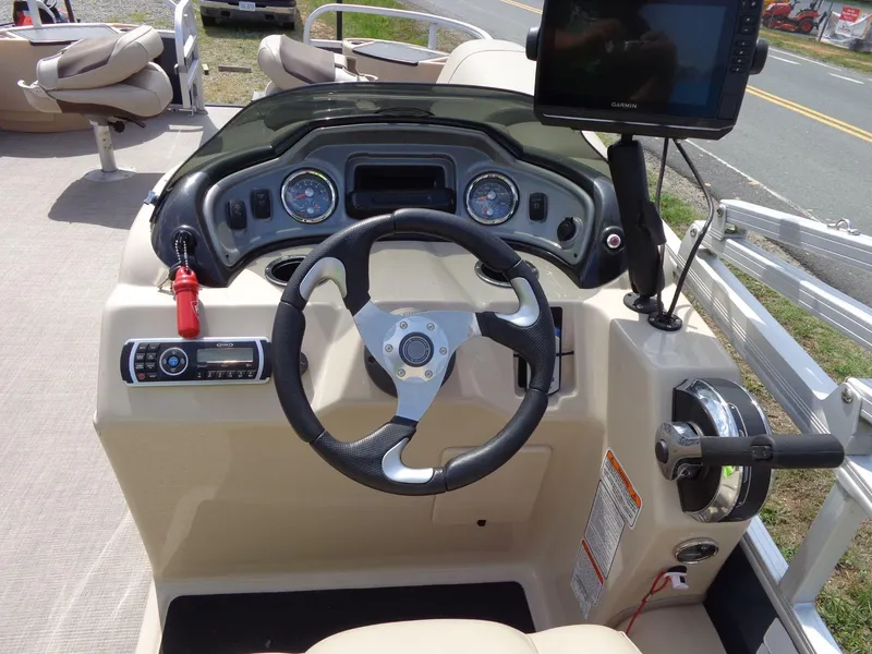 Slide: The Image of 2019 Sun Tracker Fishin' Barge 22 DLX dashboard with steering wheel and Garmin display. - 29