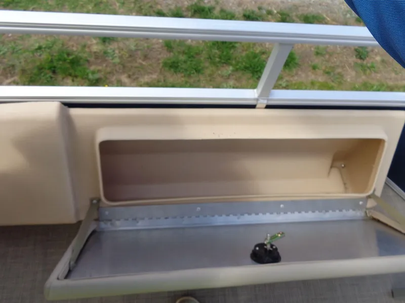 Slide: The Image of 2019 Sun Tracker Fishin' Barge 22 DLX storage compartment with open lid and railing. - 40