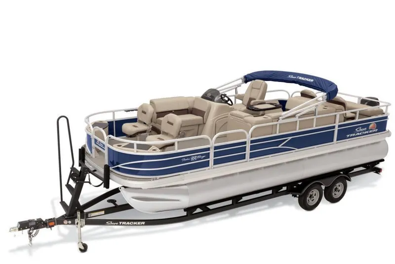 Slide: The Image of 2019 Sun Tracker Fishin' Barge 22 DLX pontoon boat on trailer, blue and beige design. - 49