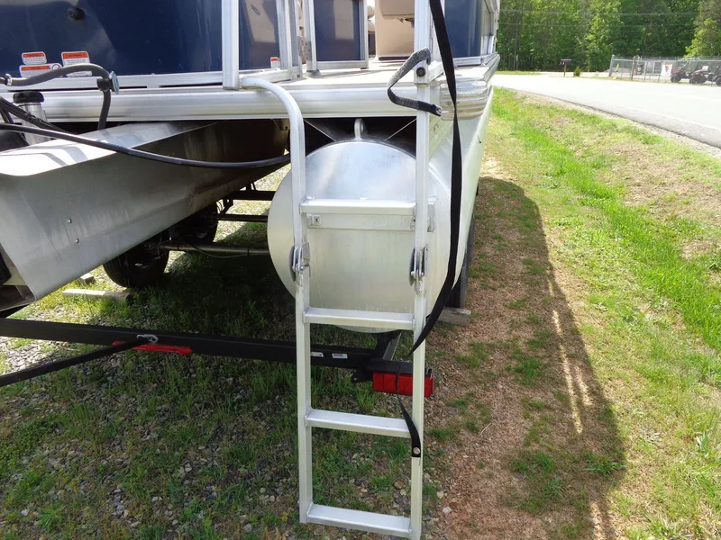 Slide: The Image of 2019 Sun Tracker Fishin' Barge 22 DLX with ladder on grassy roadside. - 9