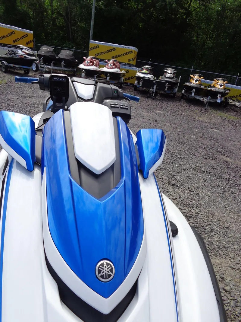 Slide: The Image of 2019 Yamaha FX Cruiser HO jet ski in blue and white, parked on gravel. - 25