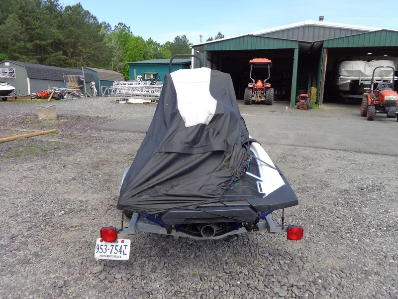 Slide: The Image of 2019 Yamaha FX Cruiser HO covered, parked near green storage buildings and tractors. - 32