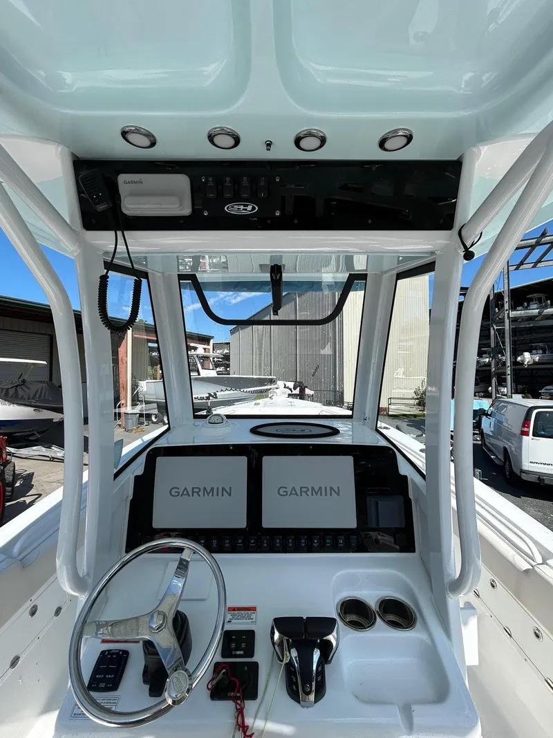 Slide: The Image of 2022 Sea Hunt Gamefish 25 boat dashboard with Garmin displays and steering wheel. - 11