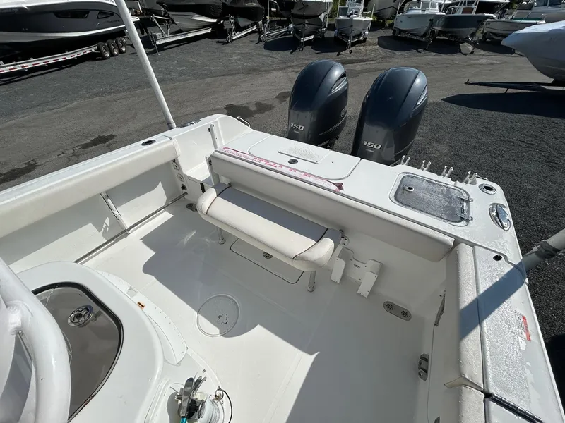 Slide: The Image of 2022 Sea Hunt Gamefish 25 boat interior with dual engines, docked outdoors. - 14