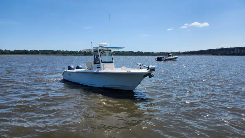 Slide: The Image of 2022 Sea Hunt Gamefish 25 boat on calm water under clear blue sky. - 21