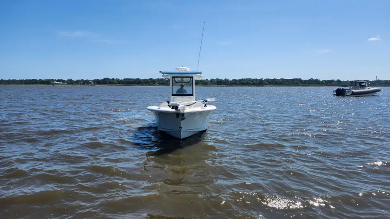 Slide: The Image of 2022 Sea Hunt Gamefish 25 boat on calm water under clear blue sky. - 22