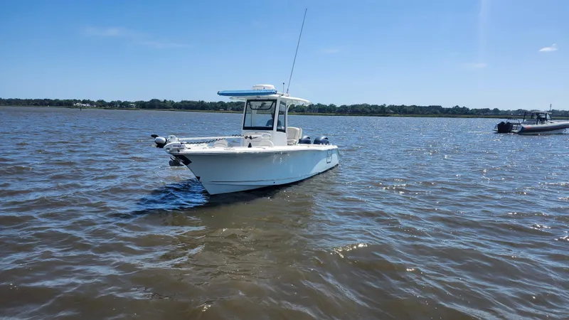 Slide: The Image of 2022 Sea Hunt Gamefish 25 boat on calm water under clear blue sky. - 23
