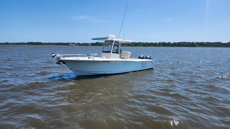 Slide: The Image of 2022 Sea Hunt Gamefish 25 boat on calm water under clear blue sky. - 24